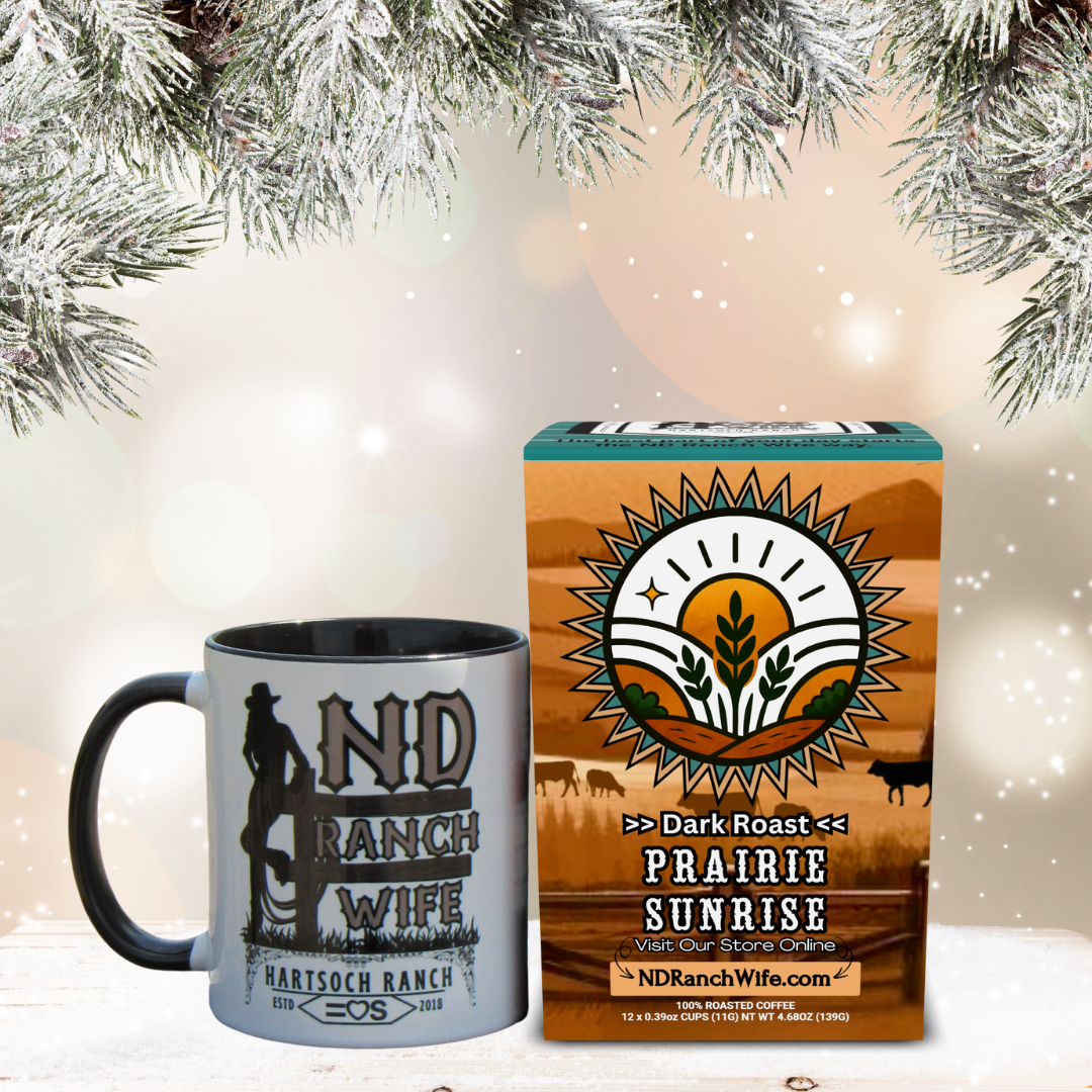 Mug and box of Prairie Sunrise coffee with ND Ranch Wife branding against a festive background.