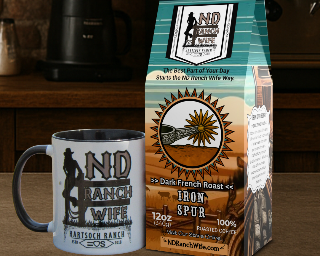 ND Ranch Wife coffee bag and mug on a wooden surface with a coffee maker in the background.