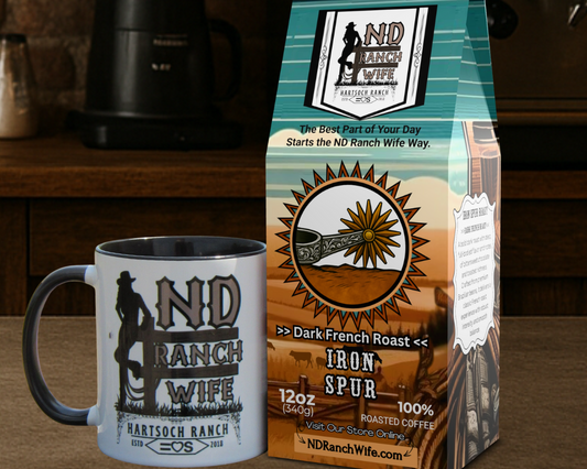 ND Ranch Wife coffee bag and mug on a wooden surface with a coffee maker in the background.