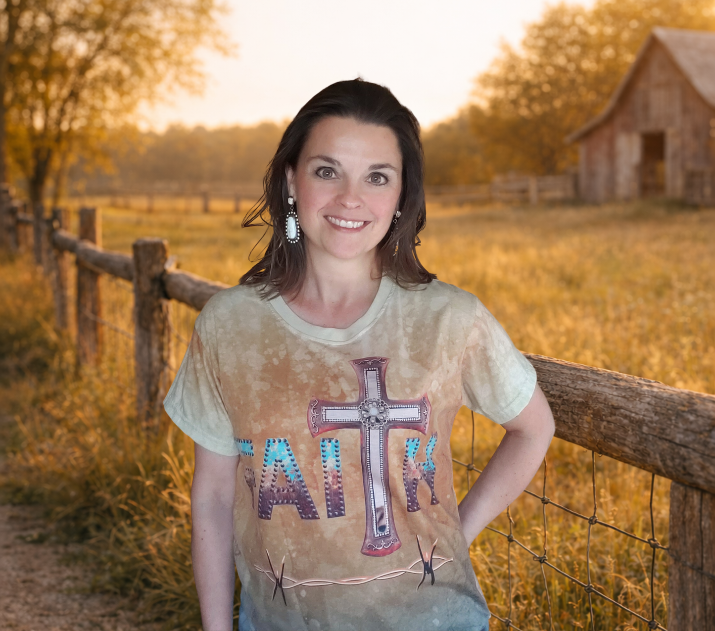 Woman wearing a t-shirt with a cross and 'Faith' text in a rural setting with a barn and fence.